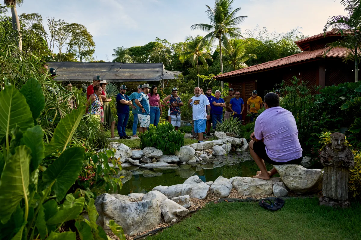 Instrutor orientando alunos ao lado de um lago ornamental
